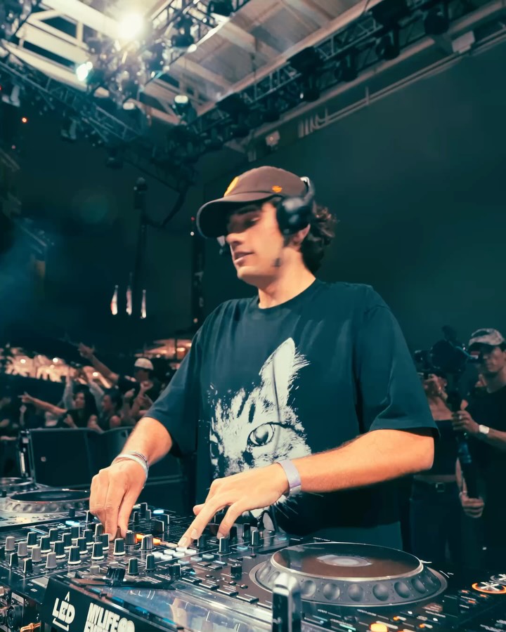 Odd Mob mixing in a brown cap and cat t-shirt, crowd hands up behind him